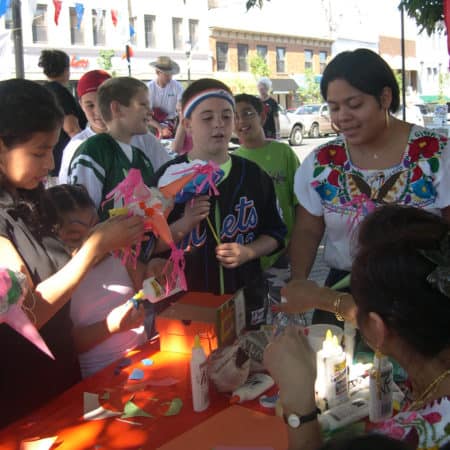 A group of people at a table constructing decorative items with paper