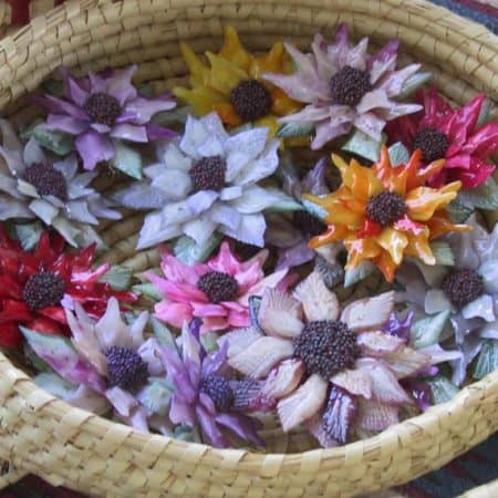 Small, colorful, flower head sculptures made from garfish scales.