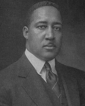Black and white headshot of John Wesley Work III, a roughly middle-aged African American man in a suit, tie and vest, with short hair and a small mustache