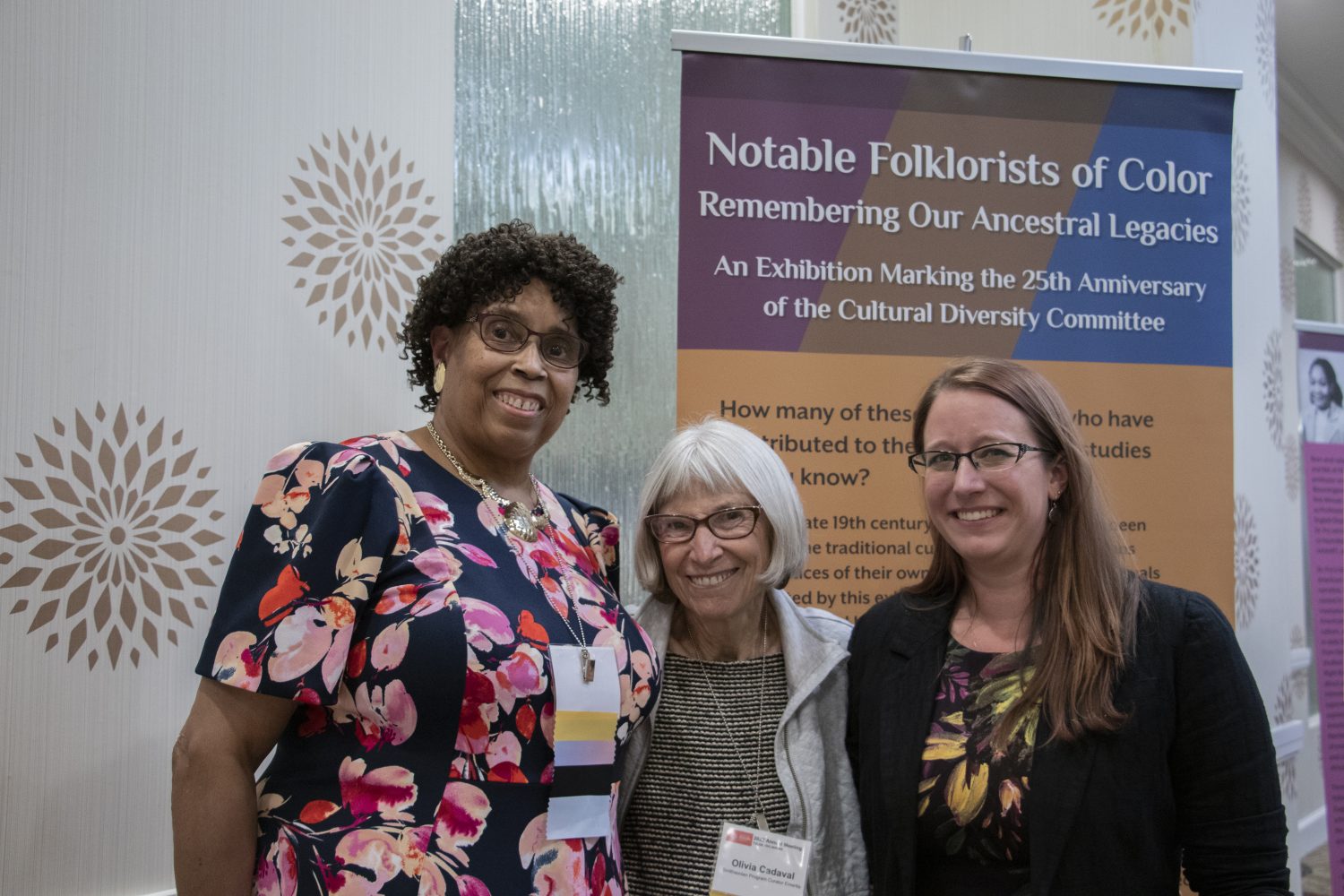 Notable Folklorists of Color creators standing in front of the title exhibition banner