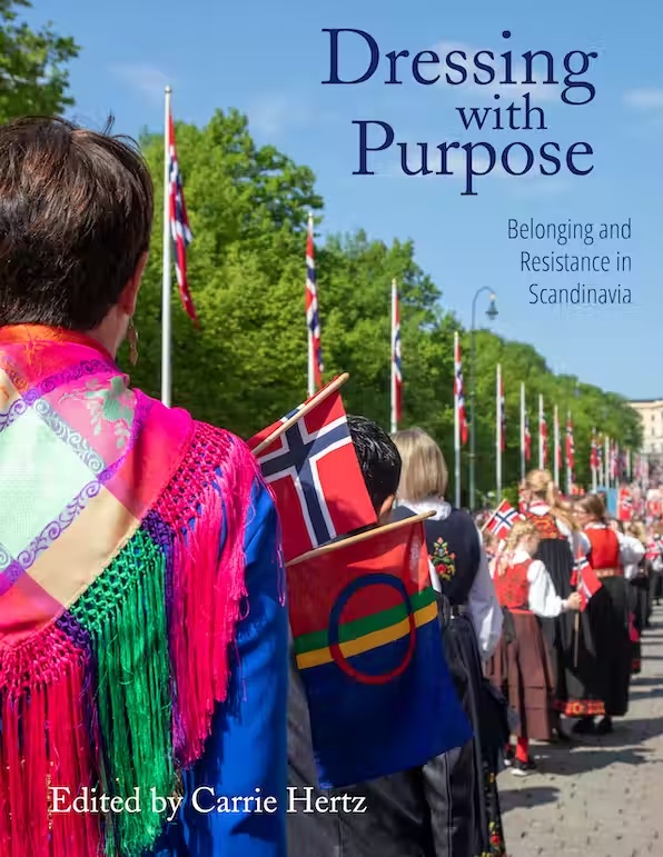colorful front cover with people with flags and traditional dress marching in a line down a street